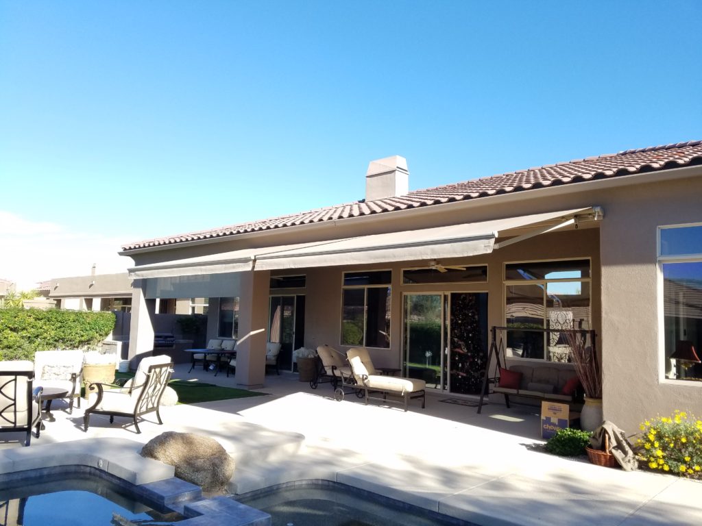 A patio with chairs and tables outside of it