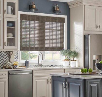 Modern kitchen with gray walls, white cabinets, and bamboo window shades.