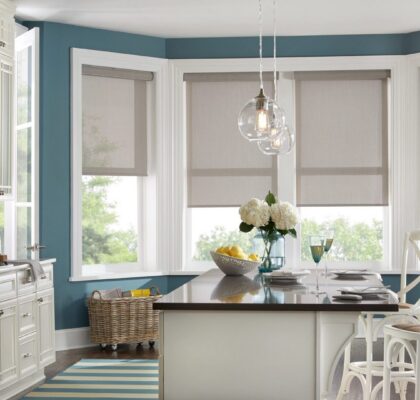 Modern kitchen with teal walls and elegant pendant lighting.