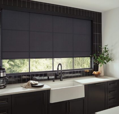 Modern kitchen with black roller blinds and a farmhouse sink.