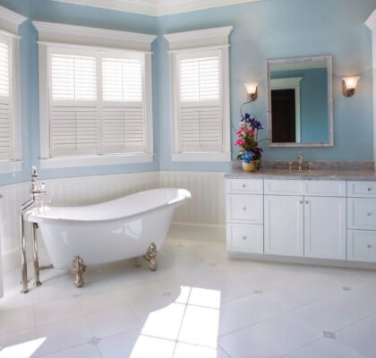 Bright, airy bathroom with clawfoot tub and white cabinetry.