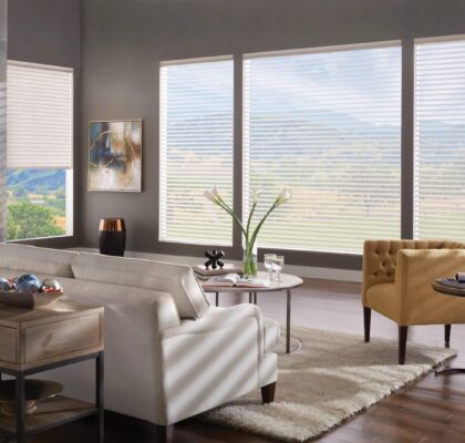 Modern living room with large windows and scenic mountain views.